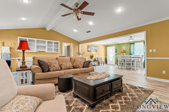 living area featuring visible vents, ornamental molding, wood finished floors, ceiling fan, and vaulted ceiling with beams