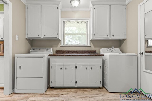 washroom with cabinet space, crown molding, washing machine and dryer, and light wood-style floors