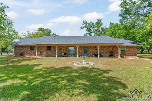 back of house featuring a yard, brick siding, and a patio area