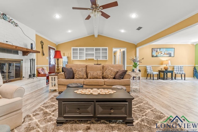 living room featuring visible vents, crown molding, wood finished floors, lofted ceiling with beams, and a ceiling fan