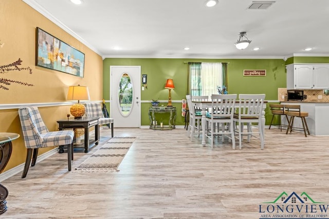 dining area featuring crown molding, light wood-type flooring, recessed lighting, and visible vents