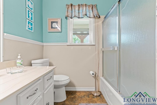 full bath featuring baseboards, enclosed tub / shower combo, vanity, and toilet