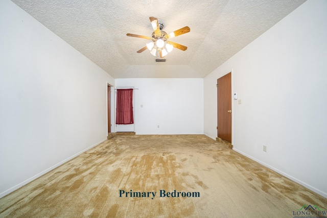 spare room with carpet flooring, a textured ceiling, vaulted ceiling, and ceiling fan