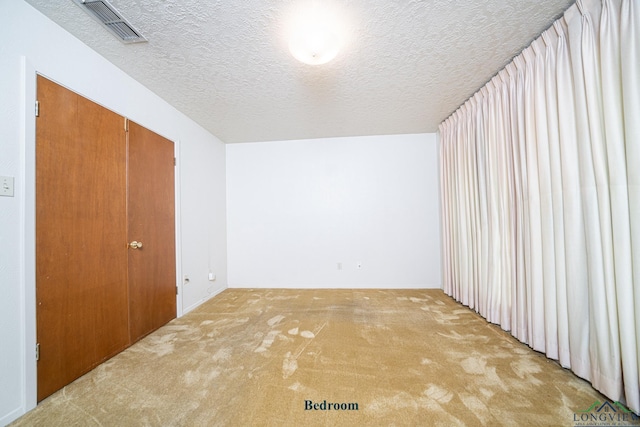 interior space featuring carpet floors and a textured ceiling