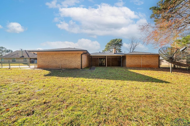 back of property featuring a yard