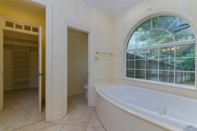 bathroom featuring tile patterned floors, toilet, and a bathing tub