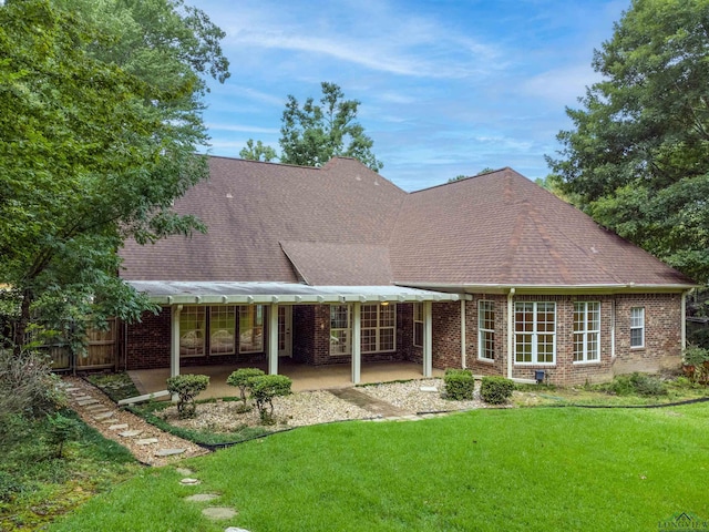 rear view of house featuring a yard and a patio area