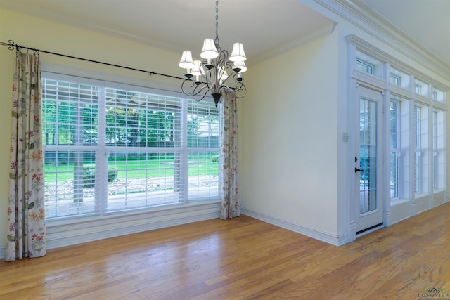 interior space with hardwood / wood-style flooring, a notable chandelier, a healthy amount of sunlight, and ornamental molding