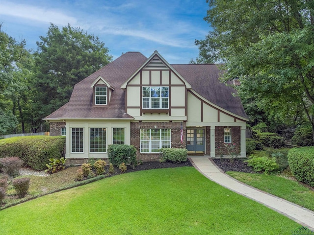 tudor home with french doors and a front lawn