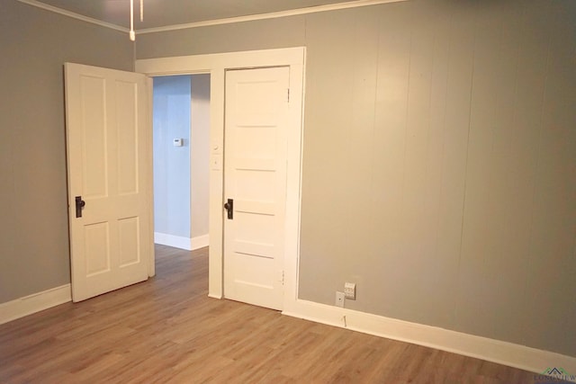 unfurnished room featuring hardwood / wood-style floors and crown molding