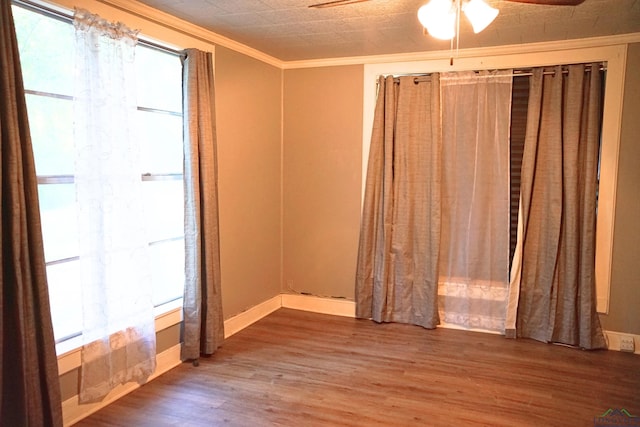 empty room with crown molding, hardwood / wood-style floors, and ceiling fan