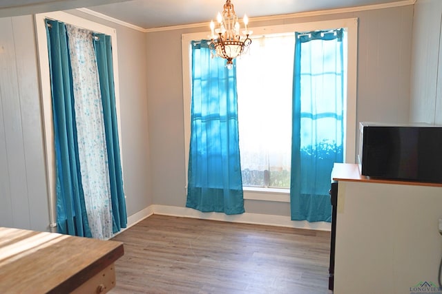 interior space with crown molding, a chandelier, and hardwood / wood-style flooring