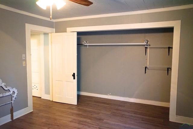 unfurnished bedroom with ceiling fan, dark hardwood / wood-style flooring, ornamental molding, and a closet