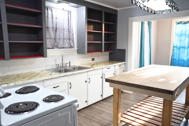 kitchen with decorative backsplash, white range with electric stovetop, sink, white cabinets, and light hardwood / wood-style floors