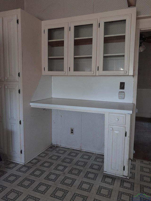 kitchen with built in desk and white cabinets