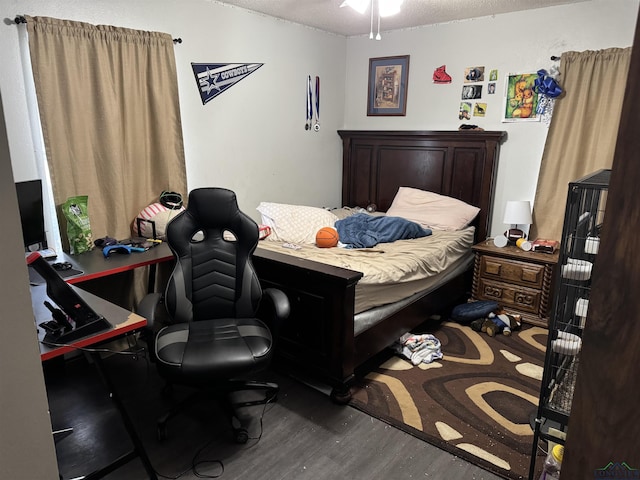 bedroom featuring a textured ceiling and wood finished floors