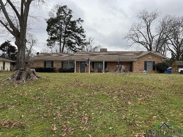 ranch-style home with a front lawn, a chimney, and brick siding