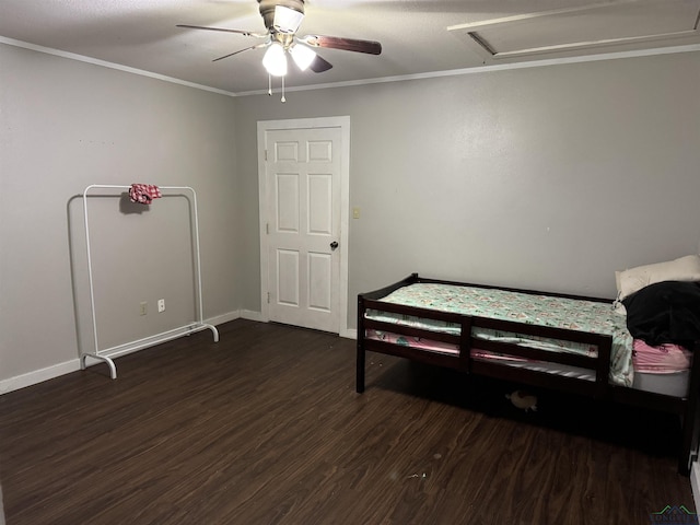 bedroom featuring crown molding, dark wood finished floors, attic access, ceiling fan, and baseboards