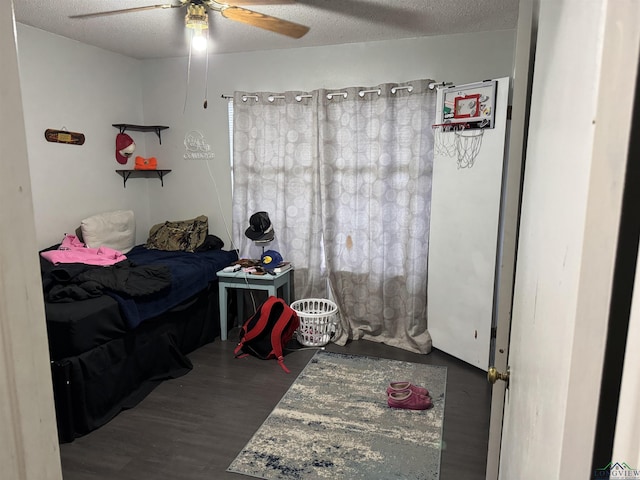 bedroom featuring a ceiling fan, a textured ceiling, and wood finished floors