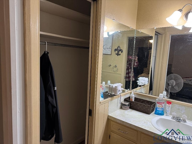 bathroom featuring a textured wall and vanity