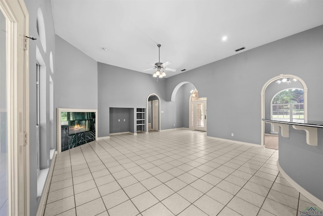 1804 W Lake Dr, Gladewater, TX 75647 - unfurnished living room with light tile patterned flooring, ceiling fan, and a tiled fireplace