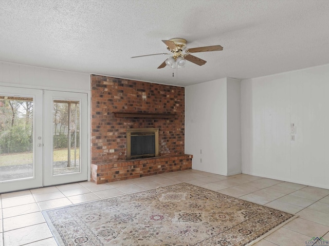 unfurnished living room with ceiling fan, french doors, light tile patterned floors, and a textured ceiling