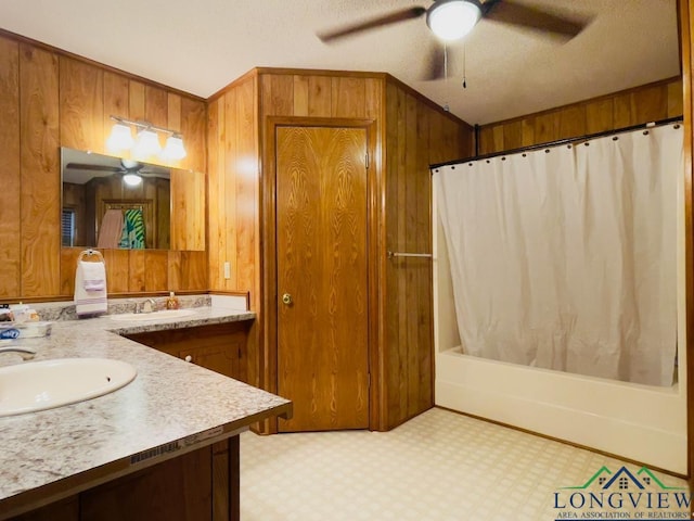 bathroom with wood walls, vanity, shower / bath combination with curtain, and a textured ceiling