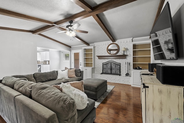 living area with a textured ceiling, lofted ceiling with beams, ceiling fan, a fireplace, and dark wood-style floors