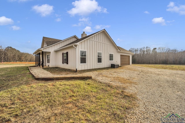 17255 Stella Maris St, Winona, TX 75792 - view of side of property featuring driveway, a yard, board and batten siding, an attached garage, and a chimney