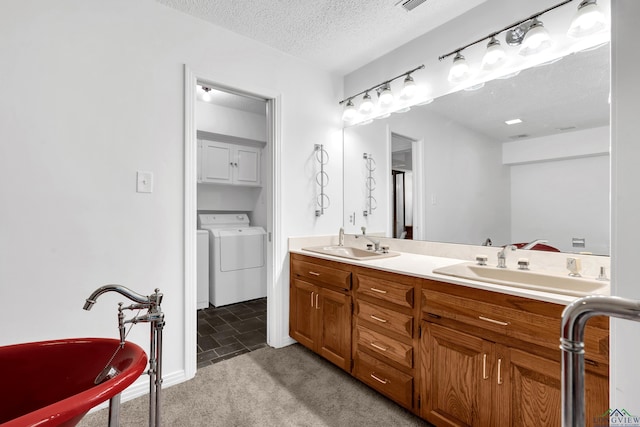 bathroom with vanity, separate washer and dryer, and a textured ceiling