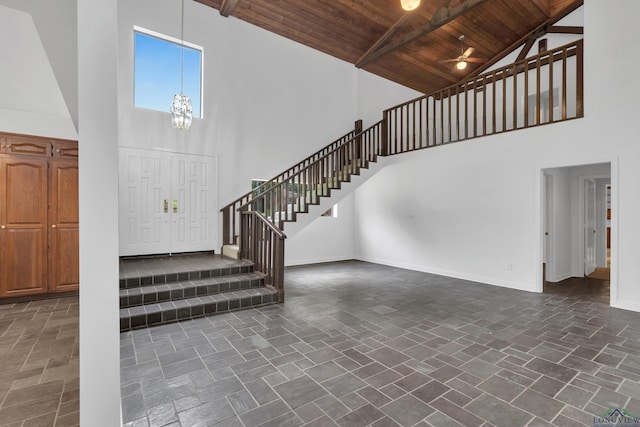 foyer entrance with beam ceiling, wooden ceiling, and high vaulted ceiling