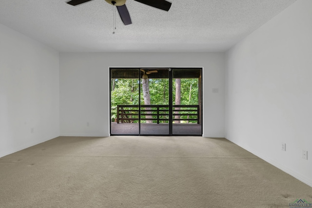 carpeted empty room featuring ceiling fan and a textured ceiling