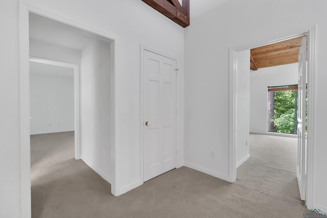 hall with wood ceiling and light carpet