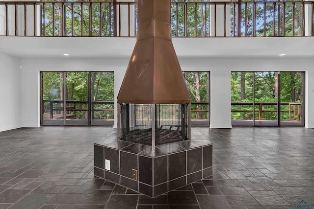 living room with a multi sided fireplace and a towering ceiling