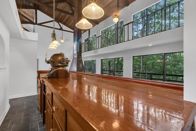 interior space with beamed ceiling, a wealth of natural light, wooden ceiling, and high vaulted ceiling