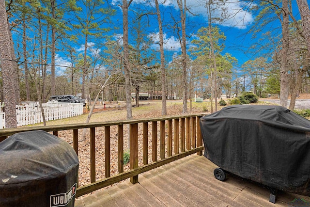 wooden terrace featuring a grill and fence