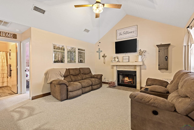 carpeted living room with vaulted ceiling, ceiling fan, a fireplace with flush hearth, and visible vents