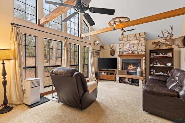 carpeted living area with ceiling fan, high vaulted ceiling, a stone fireplace, and beamed ceiling