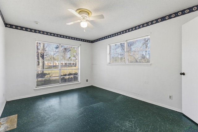 unfurnished room featuring ceiling fan and a textured ceiling