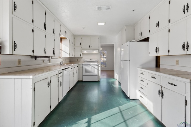 kitchen with white appliances, white cabinetry, and sink