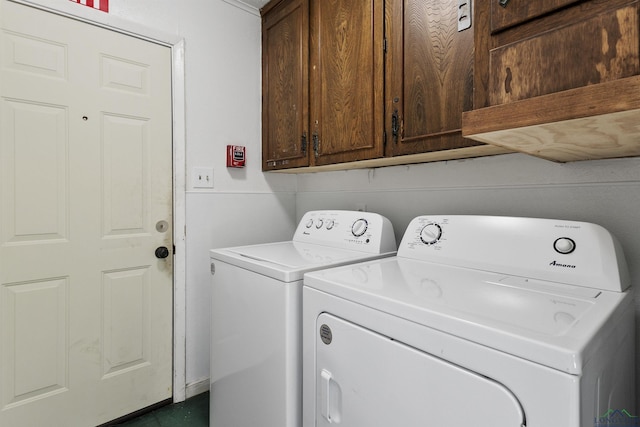 washroom with washer and clothes dryer and cabinets