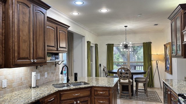 13 Oak Creek Rdg, Longview, TX 75605 - kitchen featuring a sink, backsplash, a chandelier, light stone counters, and dark brown cabinetry