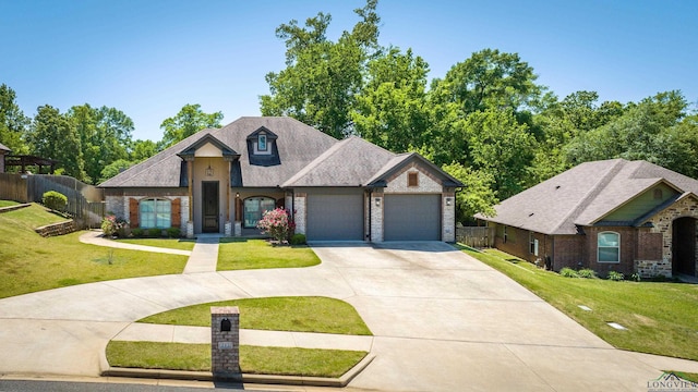 view of front of home featuring concrete driveway, fence, brick siding, a garage, and a front yard