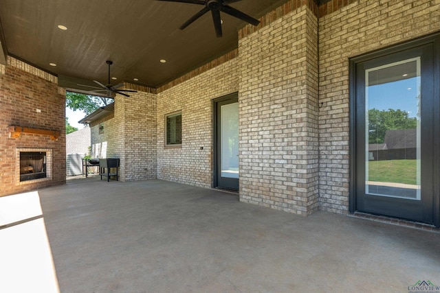 view of patio with an outdoor brick fireplace and a ceiling fan