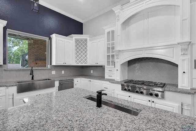 kitchen featuring tasteful backsplash, white cabinetry, stainless steel appliances, and a sink