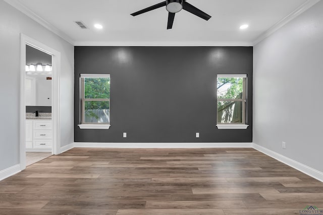 unfurnished bedroom featuring crown molding, wood finished floors, and visible vents