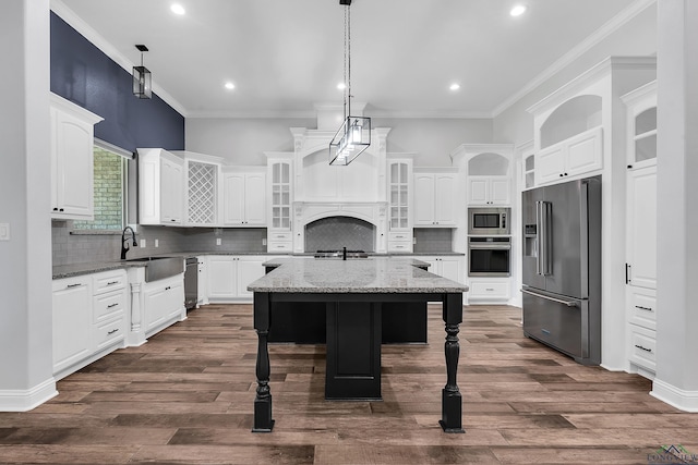 kitchen with white cabinets, stainless steel appliances, glass insert cabinets, and ornamental molding