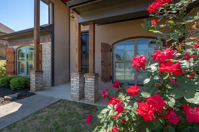 property entrance with brick siding and stucco siding
