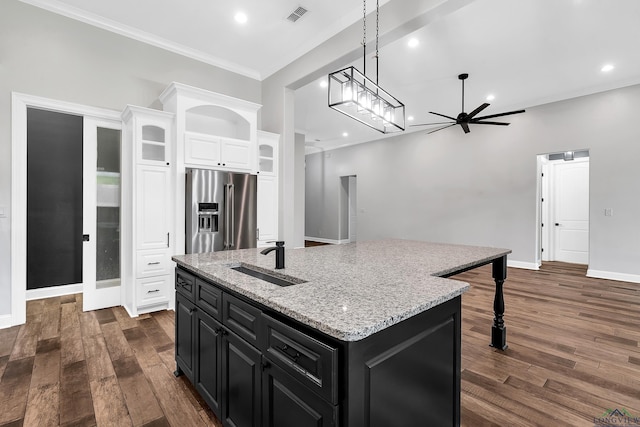 kitchen with high end refrigerator, a sink, dark cabinets, visible vents, and recessed lighting