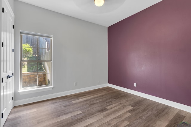 empty room with baseboards, a ceiling fan, and wood finished floors